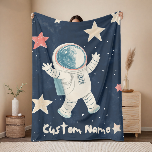 Personalized astronaut baby blanket with custom name, floating space explorer design with stars on navy background, nursery decor mockup